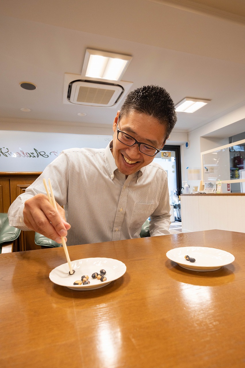 箸で豆うつしにチャレンジするスタッフT.K